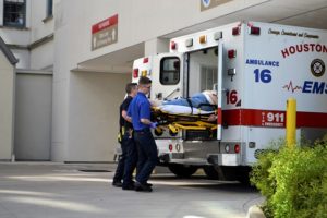 Two paramedics loading a patient into an ambulance. 
