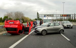 Silver and red cars involved in a car accident on the highway.