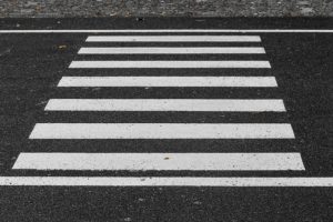 Cross walk in the street with thick white lines.